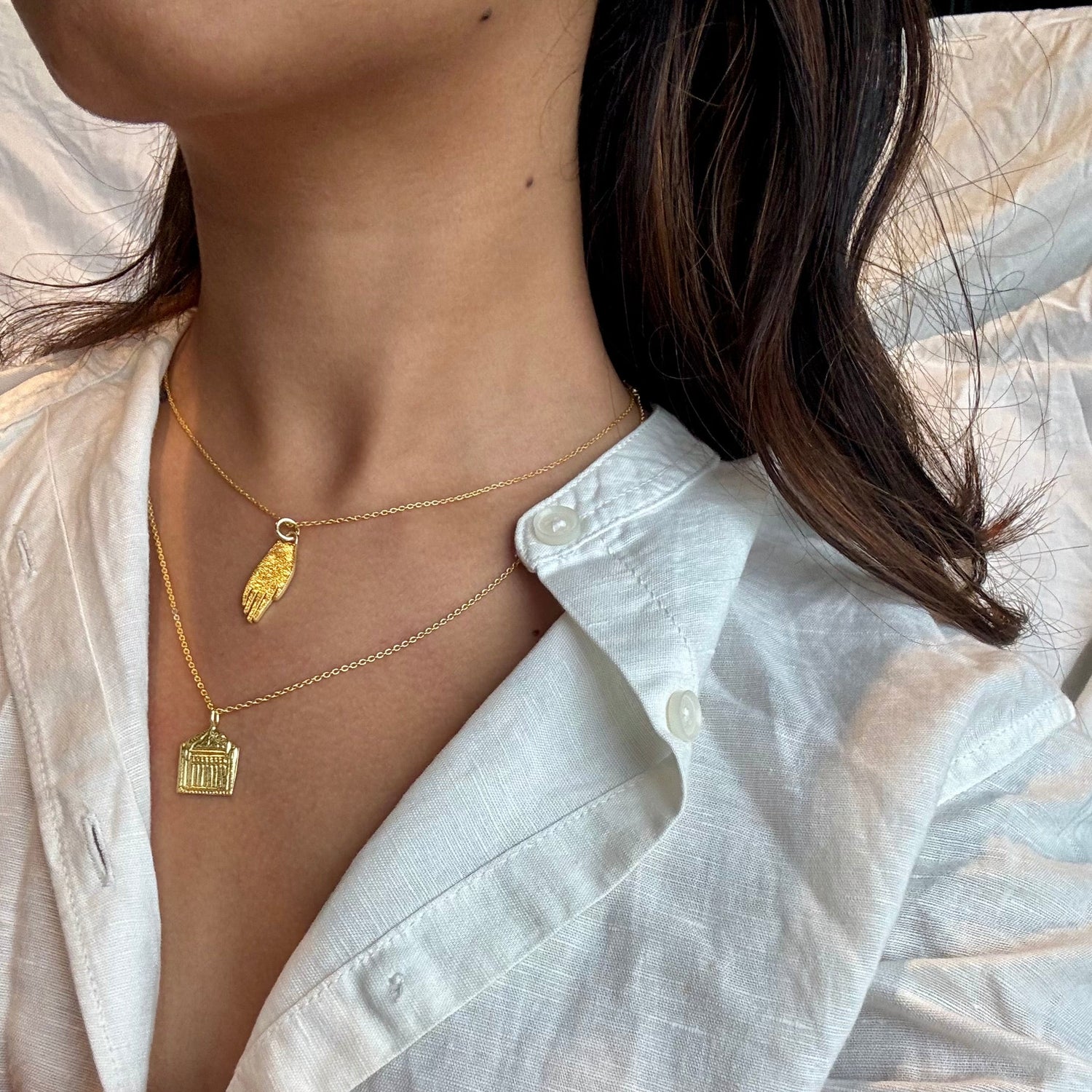  a gold necklace featuring a small pendant.